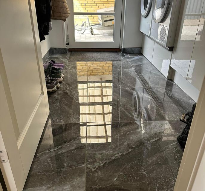 Dark gray tiles installed
          on floor in laundry room